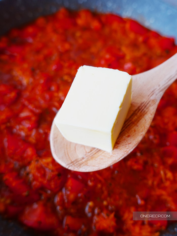 Adding unsalted butter to tomato sauce during the cooking