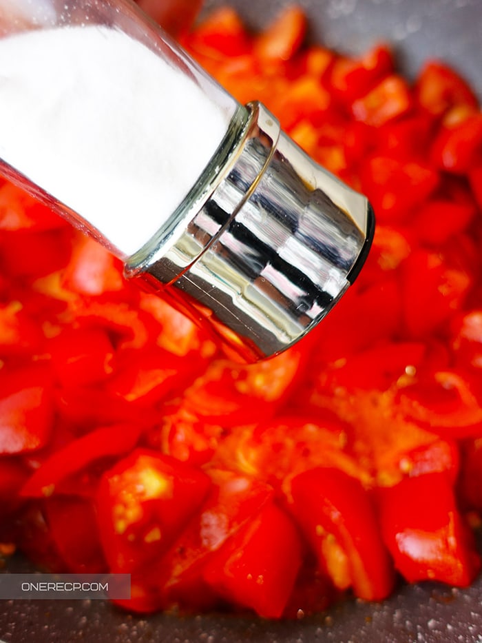 Аdding salt to tomato sauce during the cooking