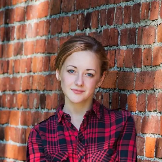 Aya, author of One ReCP, posing in front of a brick wall with a slight smile