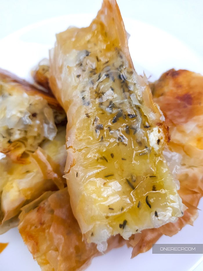 a close up of slices of banitsa showing the seasoning and the feta cheese filling