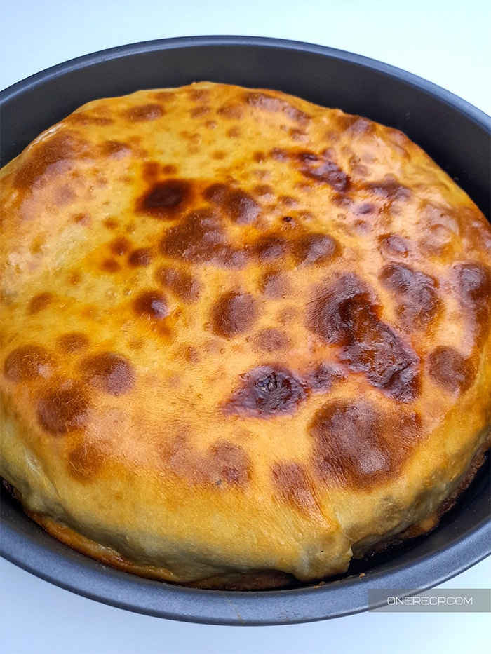 Fully cooked Bulgarian leek pie in a round baking pan
