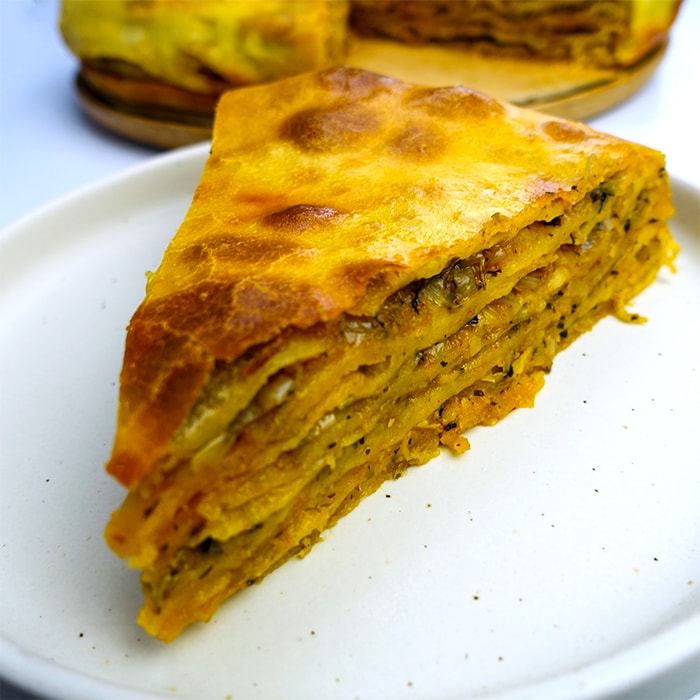 a slice of bulgarian leek pie on a plate showing all the layers inside