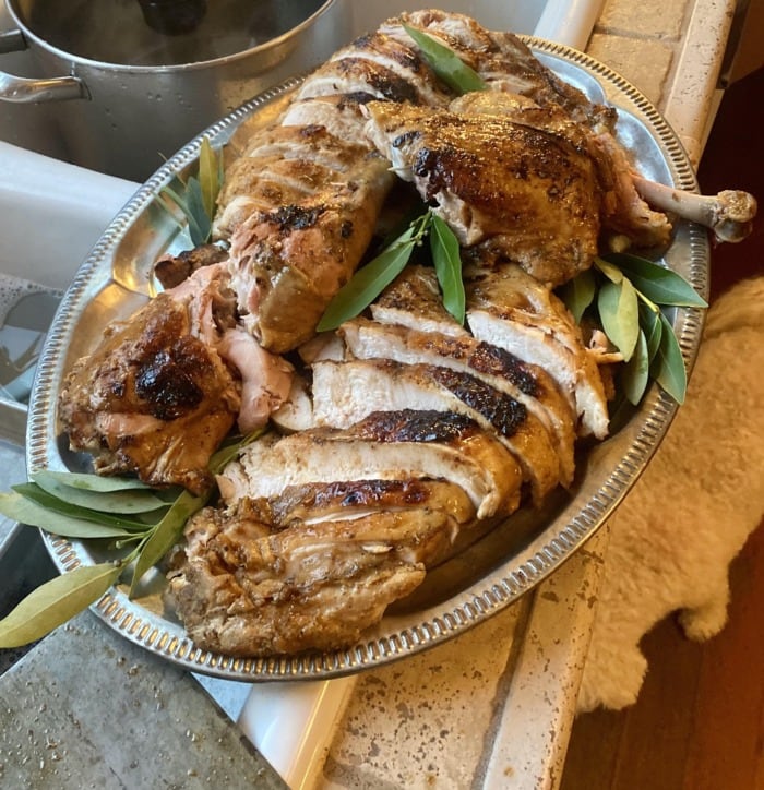 carved turkey breast and thighs on a large plate 