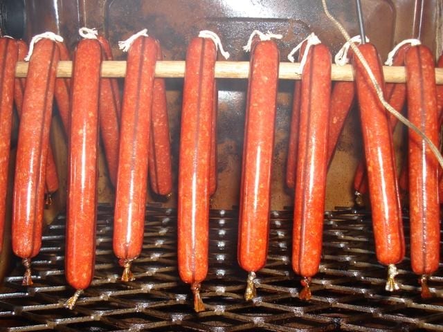 hanging homemade hotdogs with cellulose casing with a visible black line going across the length of the hotdog