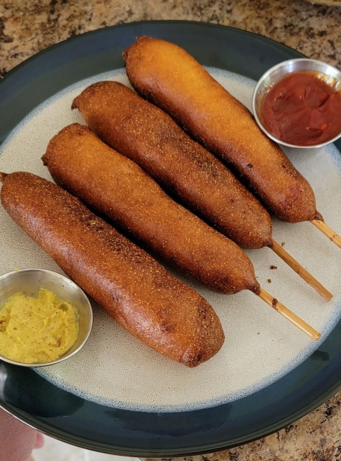 corn dogs made from vienna sausages served on a plate with mustard and ketchup