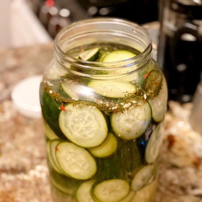 an opened jar of pickles on a kitchne counter