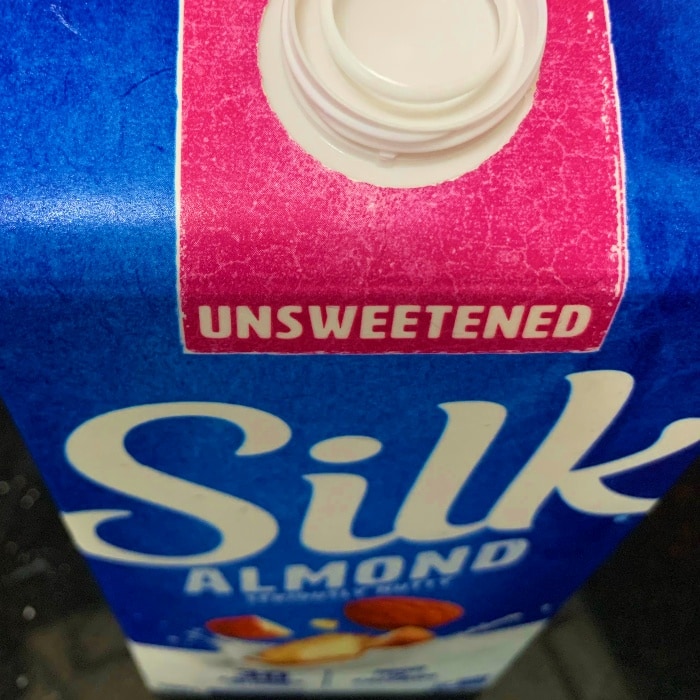 a close up of a box of unsweetened almond milk