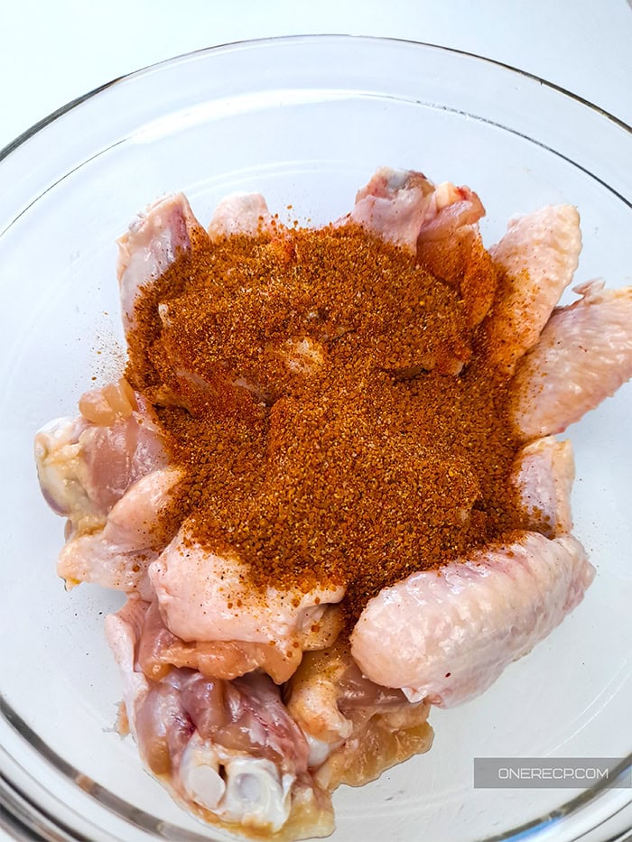 A bowl of chicken wings covered with dry rub