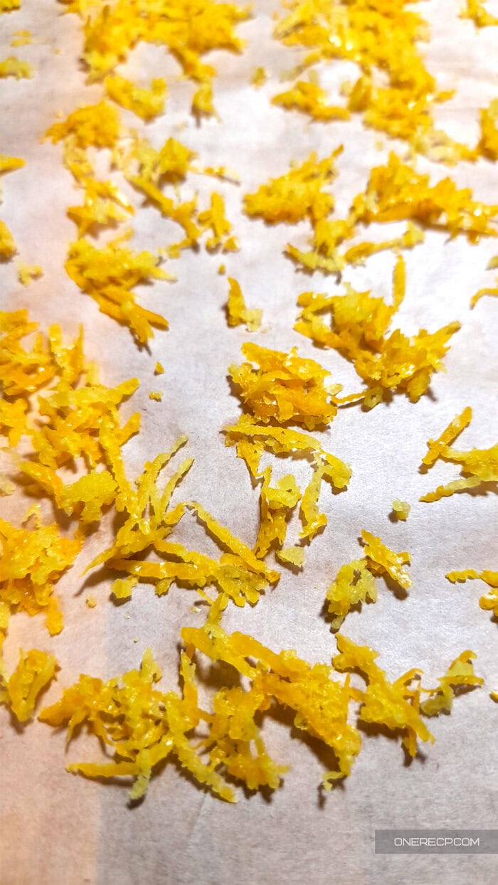 Lemon zest spread out on parchment paper to air dry for shelf-stable storage.