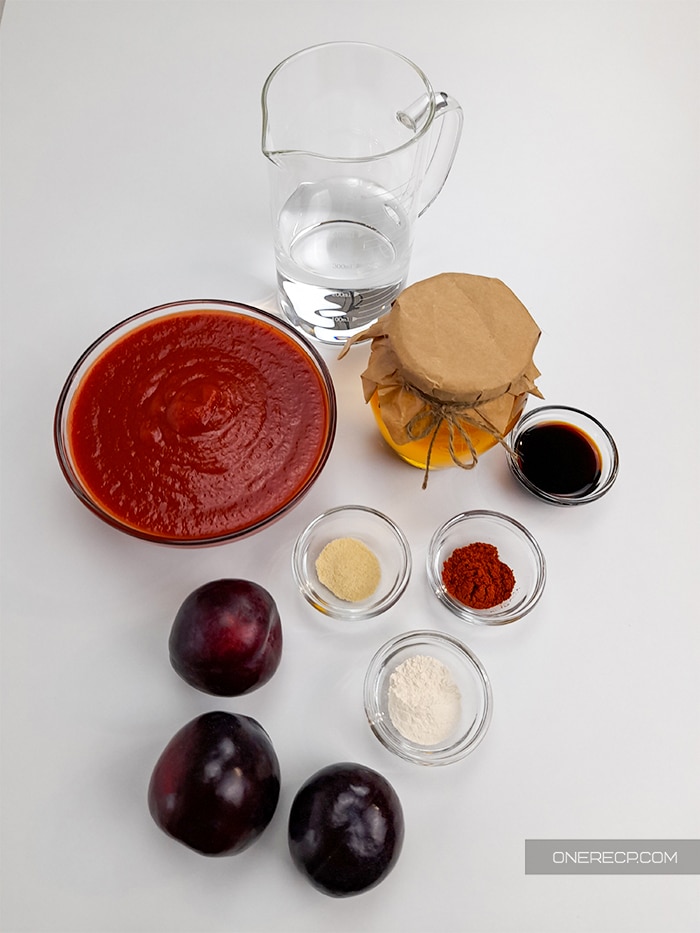 Ingredients for a bbq sauce wihtout vinegar displayed in small cups on a white kitchen board