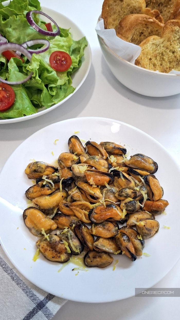 Fried mussels served with green salad and toasted bread