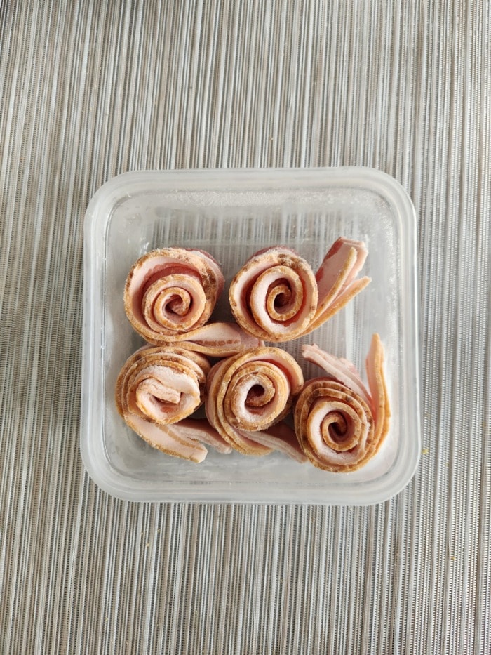 bacon made in rolls and frozen in a plastic container for later use