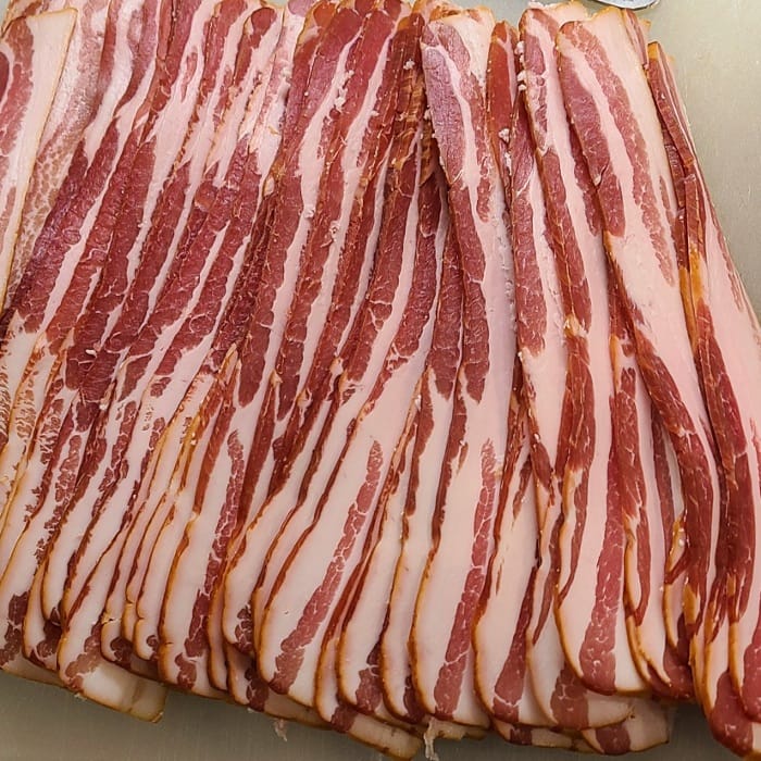 sliced of raw bacon laid on a board