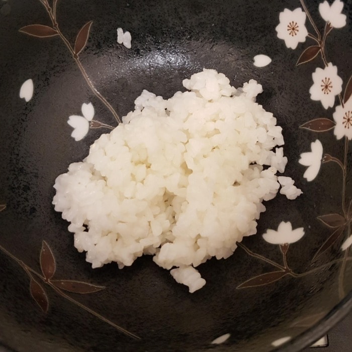 a one person portion of cooked white rice in a pan