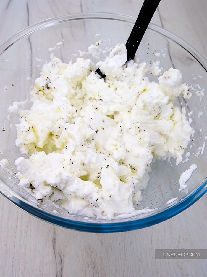 a glass bowl of the ready to use mixture of puffy egg whites, parmesan cheese, and spices