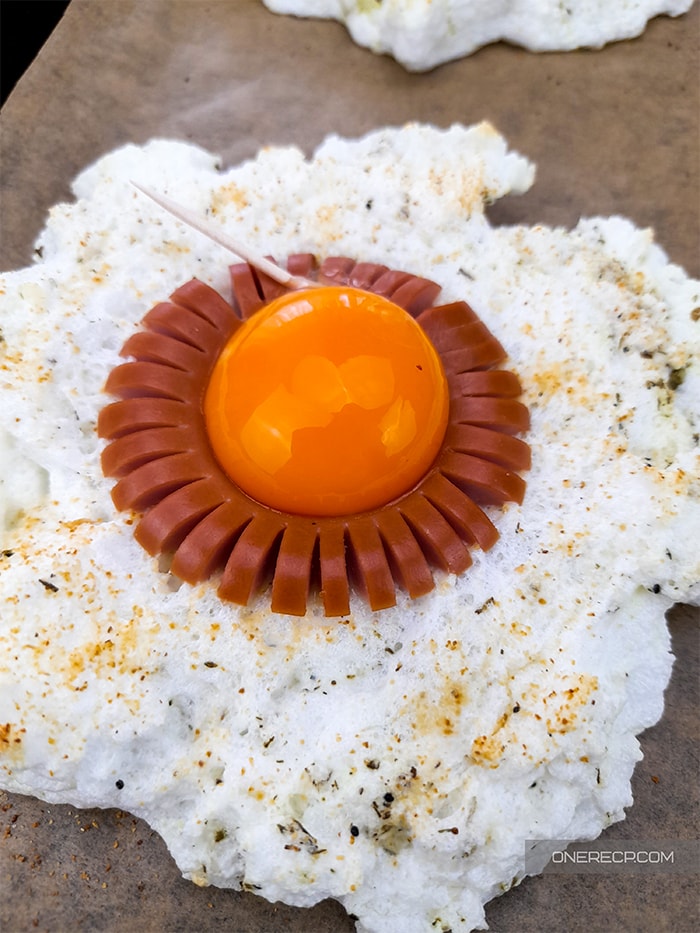 an individual cloud egg with the yolk placed on top after the first baking 