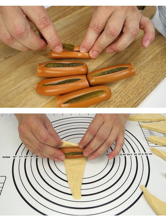 Stuffing hot dogs with pickles and rolling them in the dough.