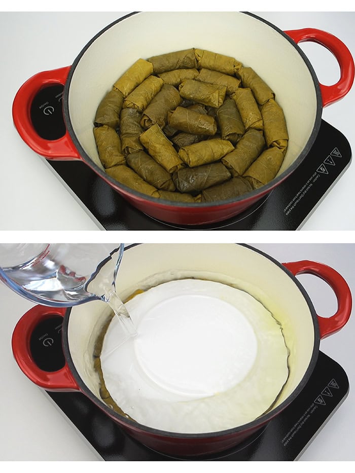 Layering stuffed grape leaves inside a pot and pressing them down with a plate