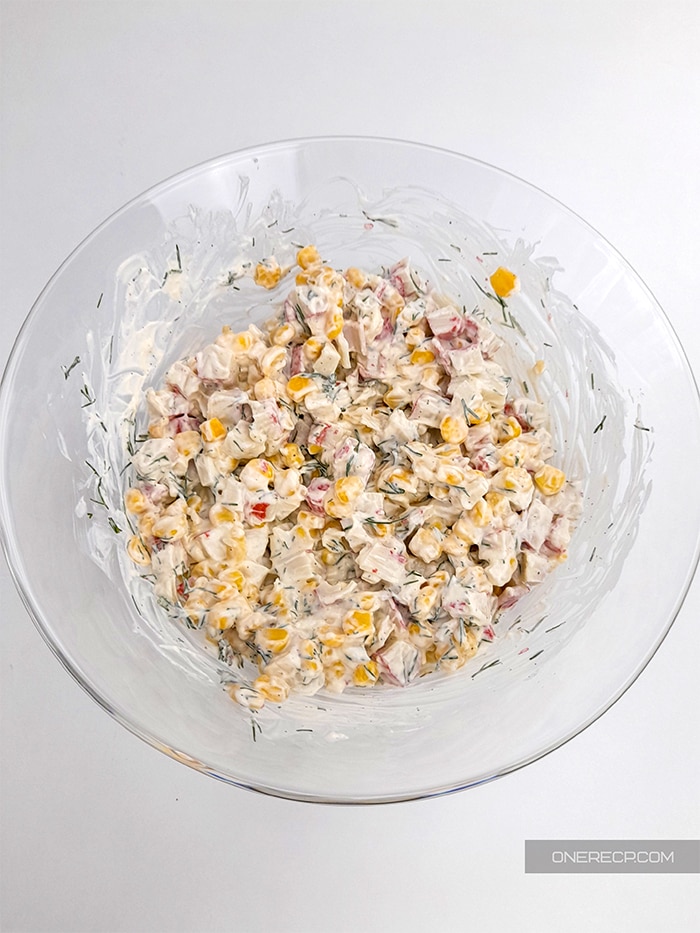 Imitation crab meat salad mixed in a glass bowl