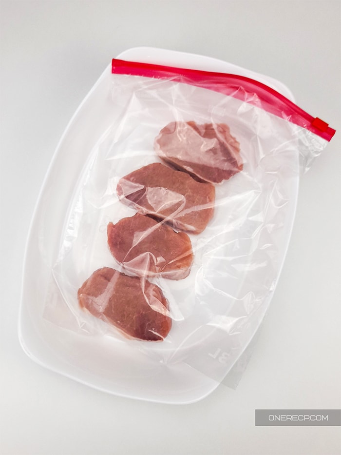 a ziploc bag with four 1-inch thick boneless pork chops