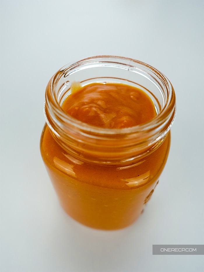 an open jar with freshly made mild buffalo wing sauce