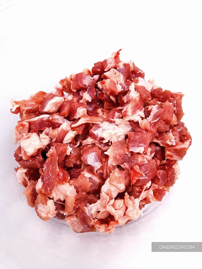 a bowl of chopped pork shoulder showing the size and consistency of the pieces