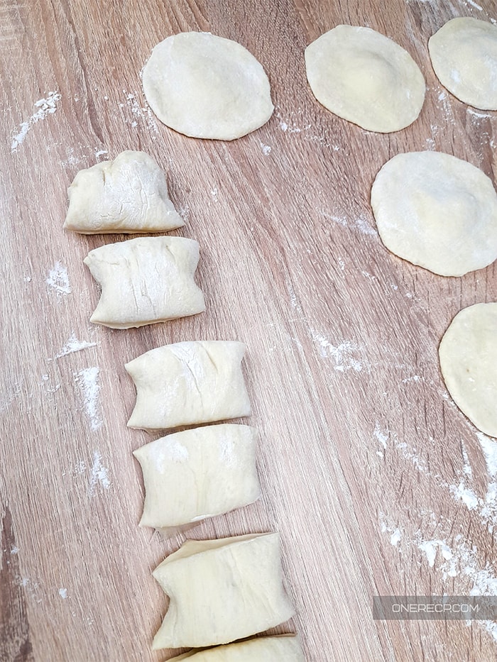 the dough is cut into smaller equal pieces and rolled into what should become buns