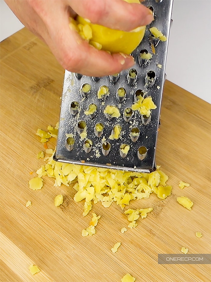 Grating boiled potatoes over a cutting board