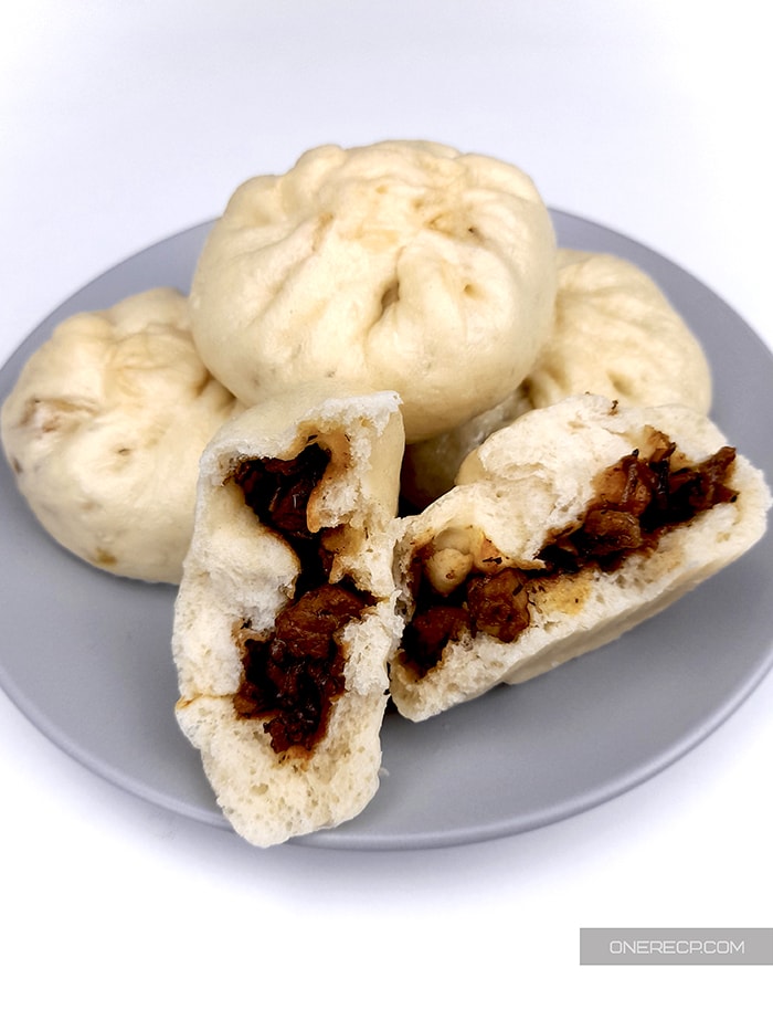 a plate with pork buns with one split so that the pork filling can be seen