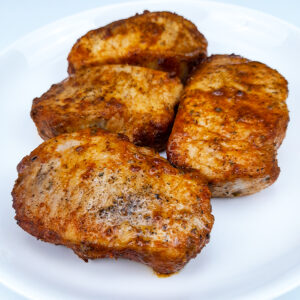 a plate with four juicy pork chops baked in the oven