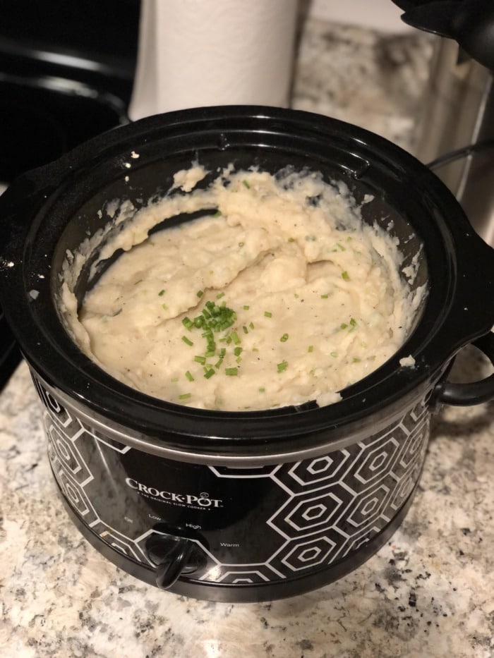 A crock pot with creamy and buttery mashed potatoes