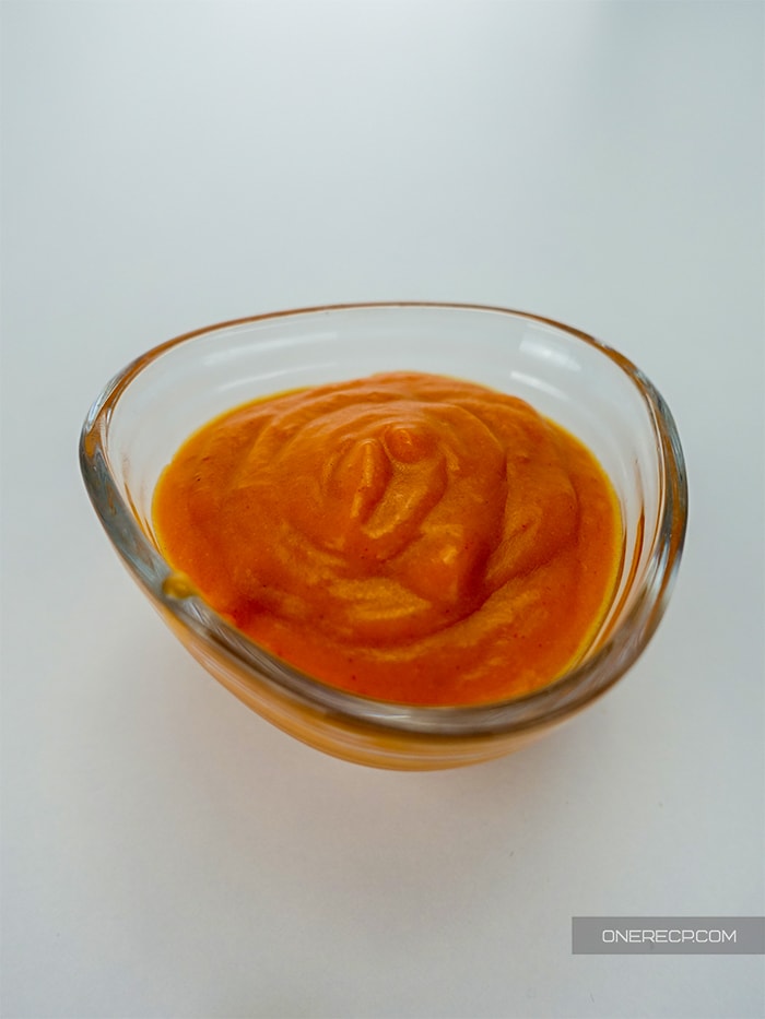 close up of the mild buffalo wing sauce in a sauce cup