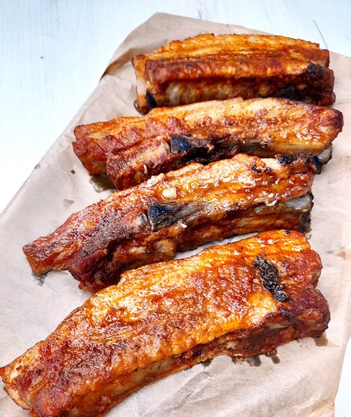 four oven baked pork spare ribs on baking parchment paper