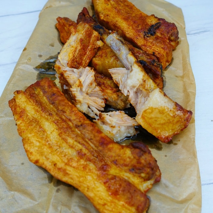 a couple of oven baked pork spare ribs with the one in the middle has the meat fallen of the bone