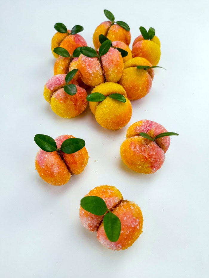 a couple of peach cookies scattered on a clean white surface