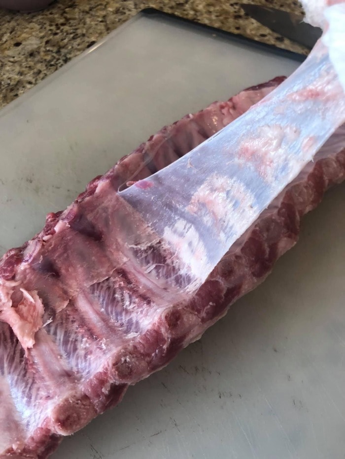 pulling the membrane from ribs by using a paper towel to grab it
