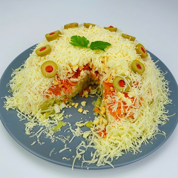 a plate with savory salad cake with a slice missing