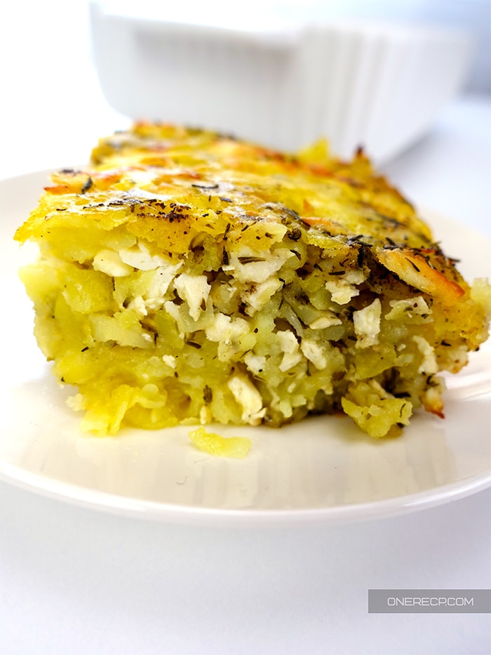 a slice of shredded potato casserole with feta cheese in a plate