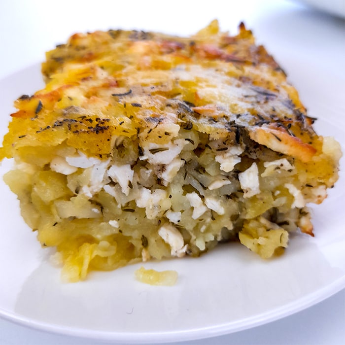 a serving of shredded potato casserole with feta cheese in a plate