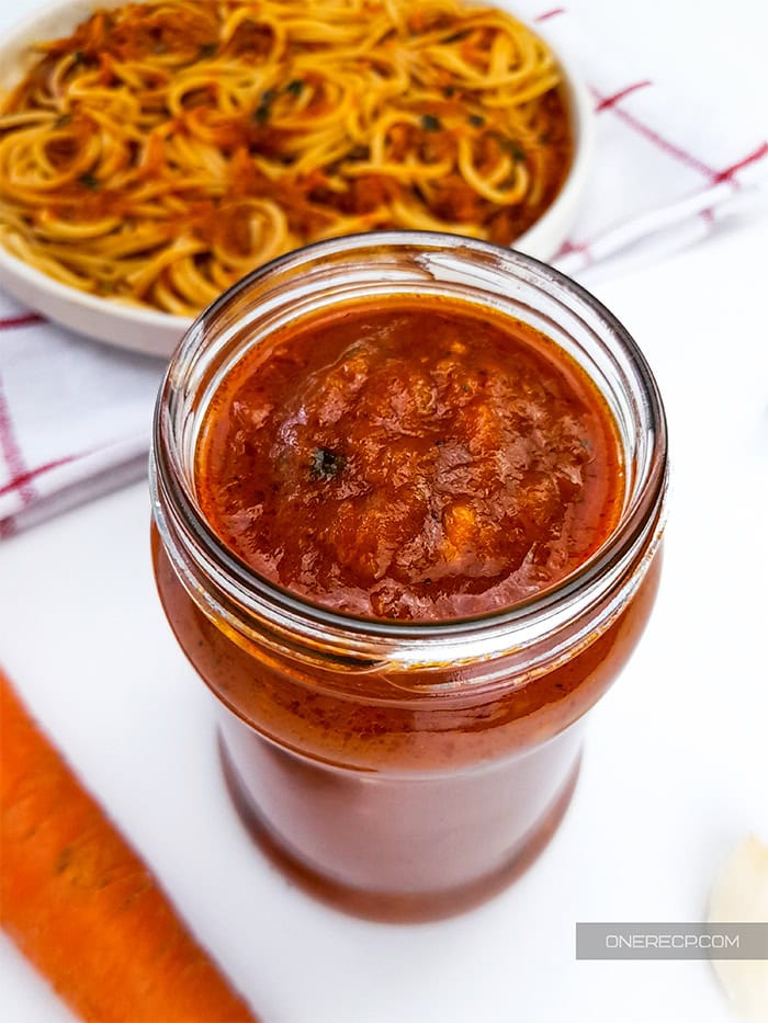 A jar with spaghetti sauce with carrots.