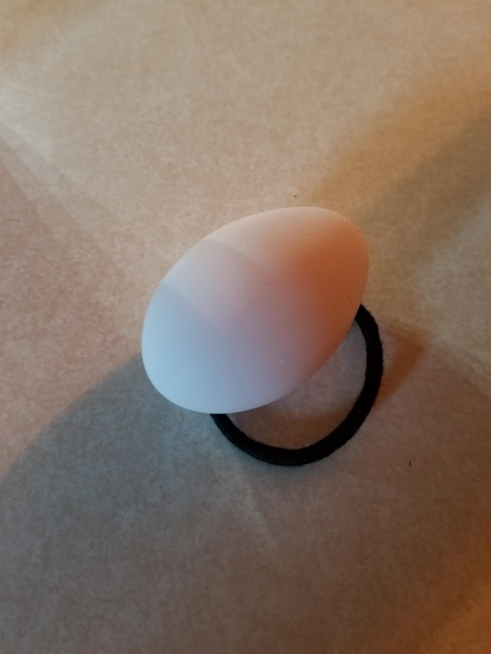 an egg on a table within a hair band
