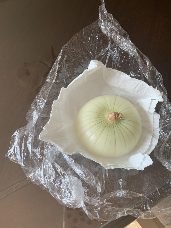 half an onion with the cut side facing down and wrapped in plastic wram and a paper towel