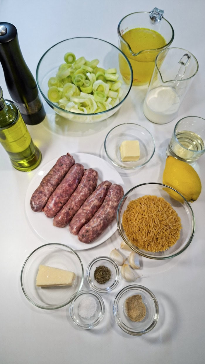 Ingredients for sweet Italian sausage orzo including sausage, leeks, orzo, Parmesan, cream, and broth