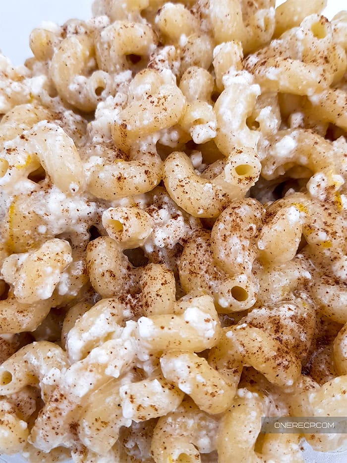 close view of a serving of sweet macaroni sprinkled with cinnamon