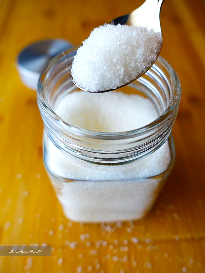 A teaspoon of sugar over a jar of sugar