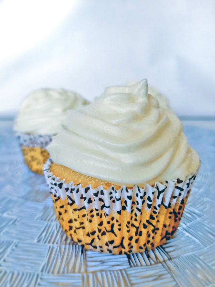 a close up of a vanilla cupcake with white vanilla frosting