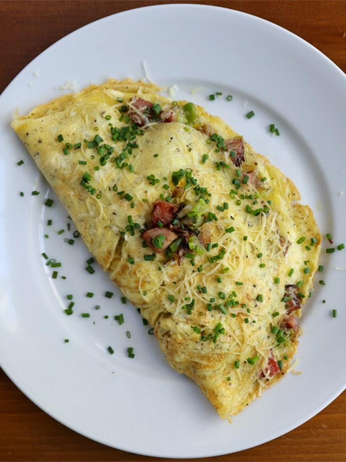an omelet with vienna sausages sprinkled with parsley