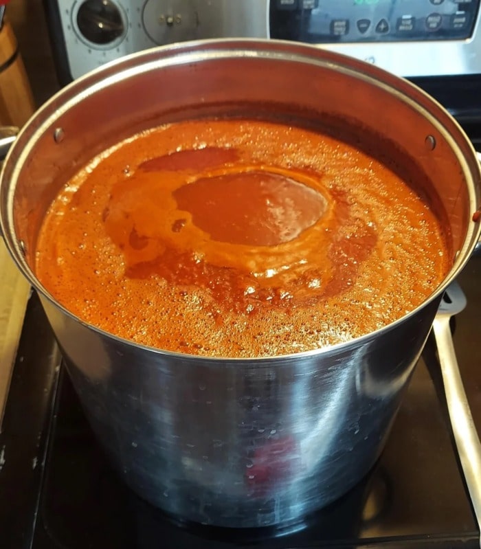 a pot of simmering tomato sauce showing the surface agitation of the sauce
