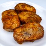 a plate with four juicy oven baked pork chops